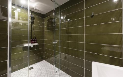 La salle de bains est pourvue d'une douche avec une porte en verre. dans l'établissement Hotel Yaja Gwangalli, à Busan
