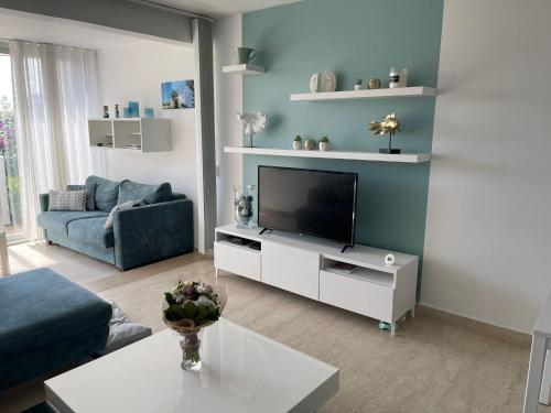 a living room with a television on a white cabinet at LE DAUPHIN by K6 Conciergerie Prestige in Cassis