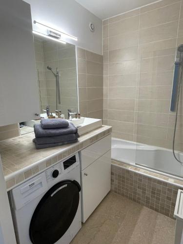 une salle de bain avec une machine à laver et un lavabo dans l'établissement LE DAUPHIN Climatisation Fibre 4 personnes, à Cassis