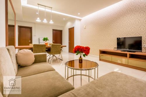 Regalia Residence @ KLCC View Sky Pool by MC في كوالالمبور: غرفة معيشة مع أريكة وتلفزيون وطاولة