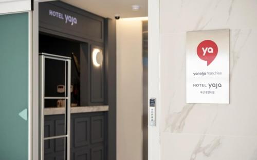 a door in a building with a sign on it at Hotel Yaja Gwangalli in Busan