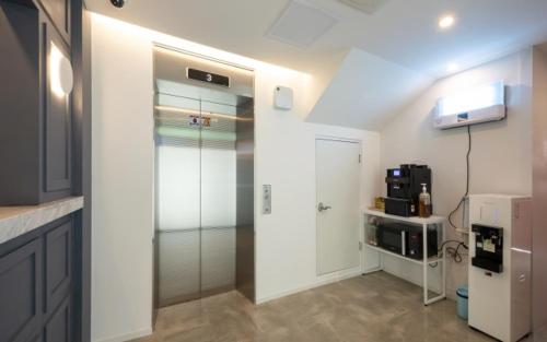 a kitchen with a walk in shower and a glass door at Hotel Yaja Gwangalli in Busan