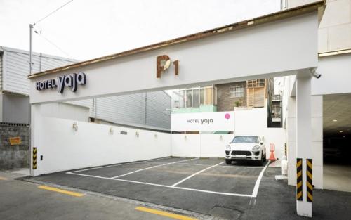 a car parked in a parking lot in front of a building at Hotel Yaja Gwangalli in Busan