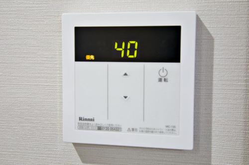 a thermometer on a wall with a clock on it at Tommy Condominium WAKASA301 in Kume
