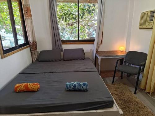 a bedroom with two beds and a desk and a chair at Treehouse Front Beach Bacong in Bacong