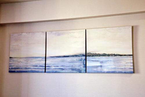 two paintings of the ocean on a wall at Tommy Condominium WAKASA301 in Kume