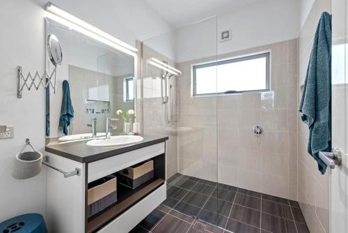 ein Bad mit einem Waschbecken und einer Dusche in der Unterkunft Scarborough beach break holidays - Unit 2 in Scarborough