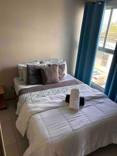 1 dormitorio con 1 cama con sábanas blancas y ventana en Casa céntrica en San Ramón, en San Ramón