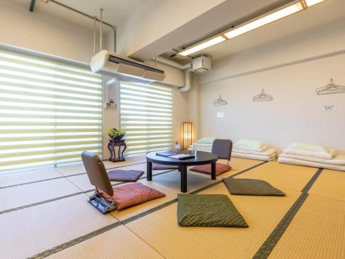 a living room with a table and a couch at Omotenashi Hostel Miyajima in Hatsukaichi