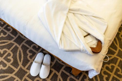 a pair of white slippers next to a bed at Grand Hyatt Beijing in Beijing