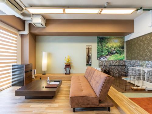 a living room with a couch and a table at Omotenashi Hostel Miyajima in Hatsukaichi