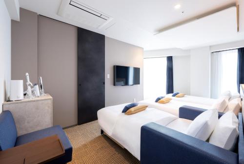 東京的住宿－HOTEL AMANEK Shinjuku Kabukicho，一间酒店客房,设有两张床和电视