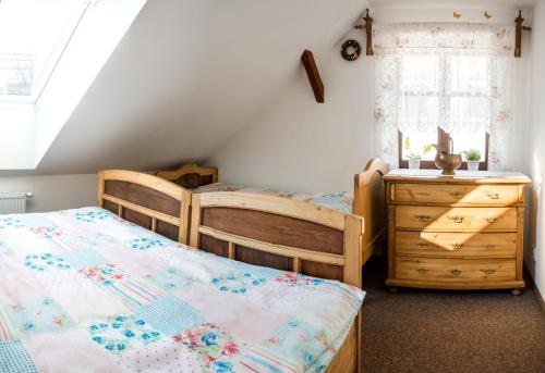 a bedroom with two beds and a dresser and a window at Penzion U Jindry in Železnice