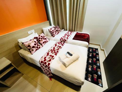 two beds in a hotel room with towels on them at Prime Hotel at TRX Tower in Kuala Lumpur