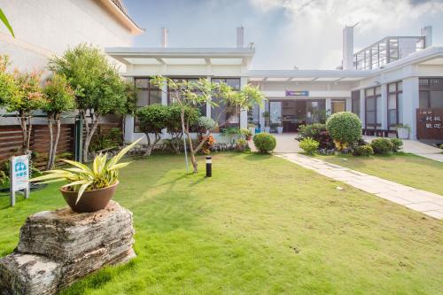 a yard in front of a building with plants at Shanban Bay Homestay in Xiaoliuqiu