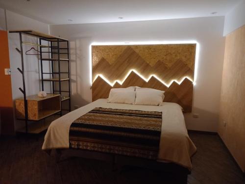 a bedroom with a large bed with a large headboard at Departamento Cumbe Mayo in Cajamarca