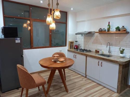 a kitchen with a wooden table and a small table and chairs at Departamento Cumbe Mayo in Cajamarca