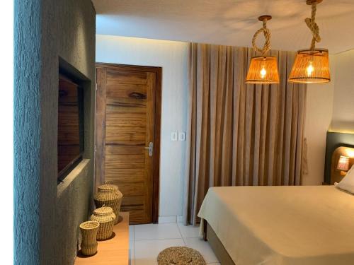 a bedroom with a bed and a wooden door at PREÁ ON BEACH in Cruz