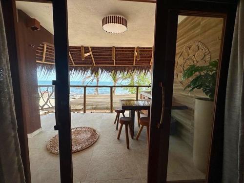 a door open to a room with a table and chairs at PREÁ ON BEACH in Cruz