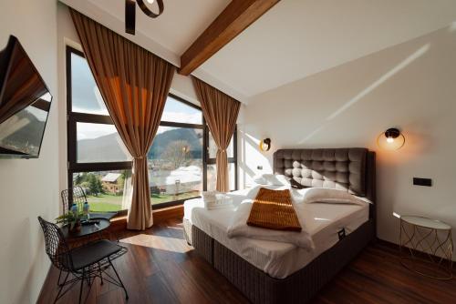 a bedroom with a large bed and a large window at Watra Chalet in Vatra Dornei