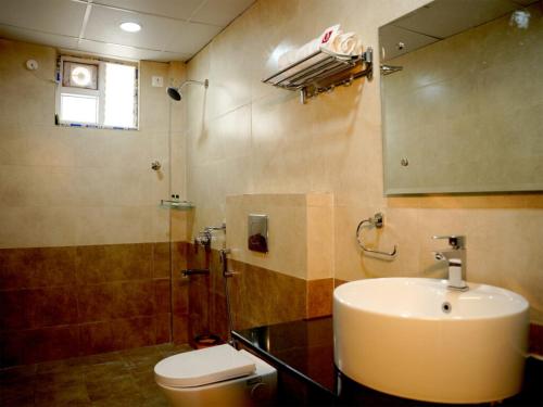 a bathroom with a sink and a toilet and a mirror at UNIQUE HOMESTAYS in Kondapur