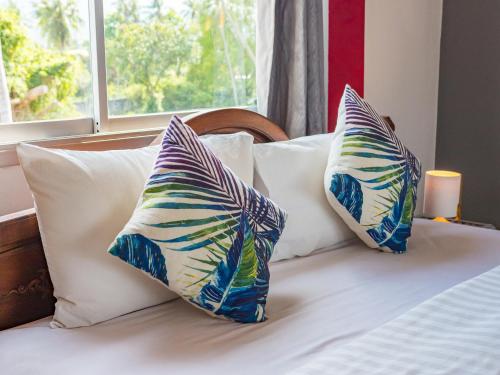 two pillows sitting on top of a bed with a window at Lemon House apartment in Mae Nam