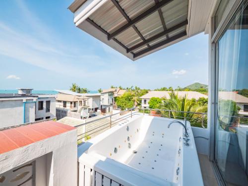a large tub on the balcony of a house at Lemon House apartment in Mae Nam