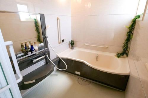 a bathroom with a bath tub with ivy on the wall at KODAKA Hotel TOKYO in Tokyo
