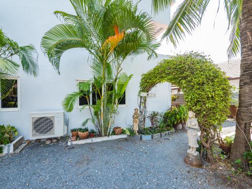 a yard with palm trees and plants in front of a house at Lemon House apartment in Mae Nam