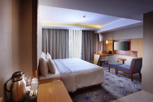 Habitación de hotel con cama y escritorio en Swiss-Belhotel Pondok Indah en Yakarta