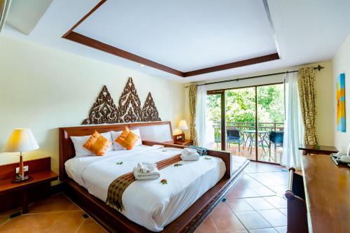 Ao Nang Bay Resort في شاطيء آونانغ: غرفة نوم بسرير كبير وبلكونة