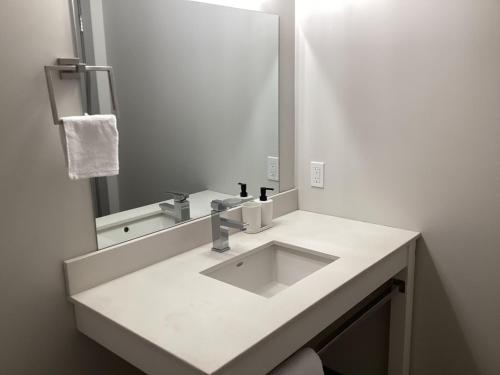 a white bathroom with a sink and a mirror at Bethel hotel Elk Point in Elk Point