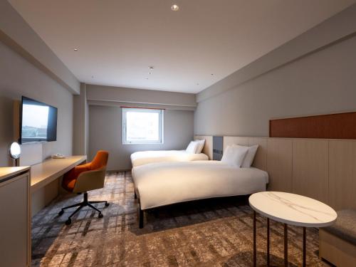 a hotel room with two beds and a desk at ANA Crowne Plaza Akita by IHG in Akita
