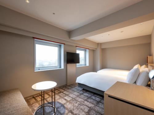 a hotel room with a bed and a table at ANA Crowne Plaza Akita by IHG in Akita
