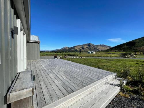 a wooden deck on the side of a house at Pudding Hill Lodge & Chalets in Mount Hutt