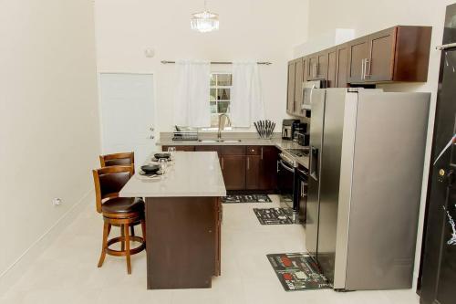 a kitchen with a refrigerator and a table and chairs at Luxurious 3-BDRM/King Bed/Gated/Near Ocho Rios in Boscobel