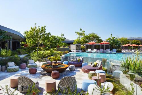 a patio with chairs and a swimming pool at Elements Of Byron in Byron Bay