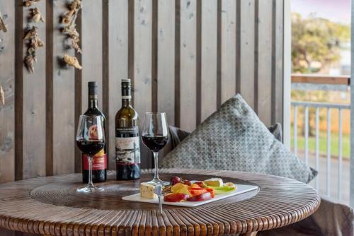 a table with two bottles of wine and a plate of fruit at Scarborough Beach Break Holidays - Unit 3 in Scarborough