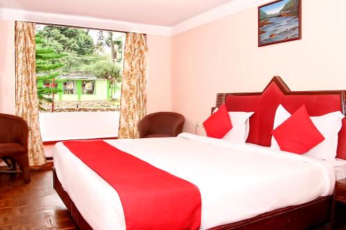 a bedroom with a red and white bed with a window at Hotel SV International in Kodaikānāl