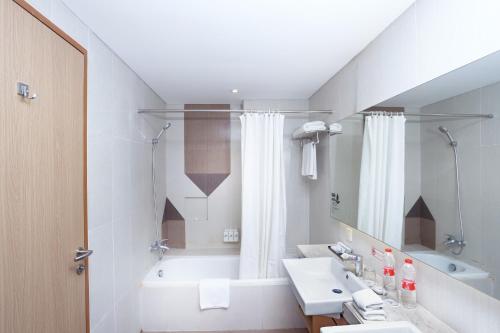 y baño con bañera, lavamanos y bañera. en Swiss-Belhotel Pondok Indah en Yakarta