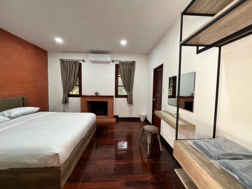 1 dormitorio con 1 cama grande y chimenea en D.I.N @ทองผาภูมิ, en Ban Pracham Mai Bon