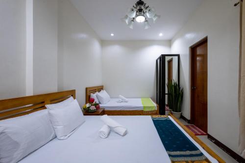 ein Schlafzimmer mit zwei Betten und einem Kronleuchter in der Unterkunft Casa Limpieza Staycation @ Tagaytay Country Homes 1 in Tagaytay