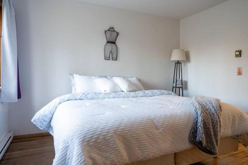 a bedroom with a bed with white sheets and a lamp at Lovely Liberty Chalet On the Waterfront in Liberty