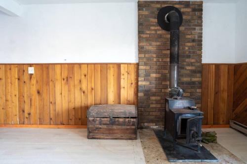 a wood stove in a room with a brick wall at Lovely Liberty Chalet On the Waterfront in Liberty