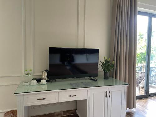 a tv on top of a white cabinet in a living room at Lynh's Villa in Cat Ba