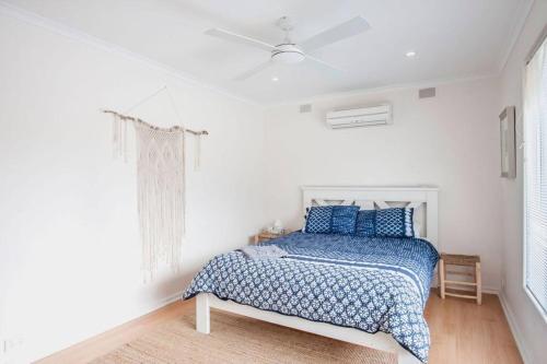 a white bedroom with a bed with blue pillows at Almonta Escape - COFFIN BAY - Perfect for couples or families in Coffin Bay