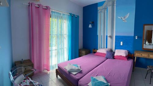 a bedroom with a purple bed and a window at Garden House in Hora Sfakion