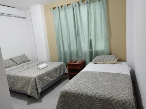 a bedroom with two beds and a window at Casa D'Lucas in Puerto Baquerizo Moreno