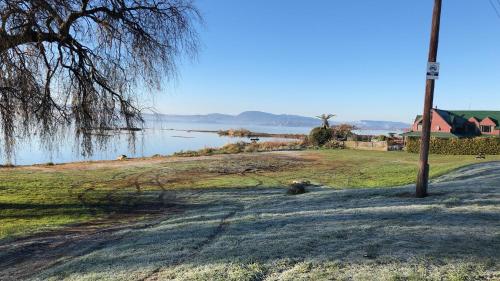 a view of a lake with a house and a pole at Lakeview Small Studio in Rotorua