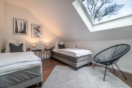 two beds in a attic room with a skylight at - DESIGN & STYLE - Modern House with terrace & garden in Wesel